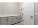 Laundry room with sink, cabinets, and tile floor at 5170 N 186Th Dr, Litchfield Park, AZ 85340