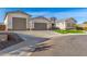 Modern home exterior with a three-car garage and artificial turf at 5170 N 186Th Dr, Litchfield Park, AZ 85340