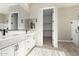 Double vanity bathroom with a large mirror, walk-in closet, and shower at 5170 N 186Th Dr, Litchfield Park, AZ 85340