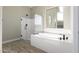 Bathroom with soaking tub, glass shower, and large window at 5170 N 186Th Dr, Litchfield Park, AZ 85340