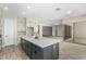 Open kitchen with an island, white cabinets, and views into adjacent living areas at 5170 N 186Th Dr, Litchfield Park, AZ 85340