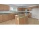 Modern kitchen with light wood cabinets, an island, and stainless steel appliances at 355 W Jersey Way, San Tan Valley, AZ 85143