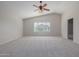 Spacious main bedroom with carpeted floor, large window and ceiling fan at 355 W Jersey Way, San Tan Valley, AZ 85143