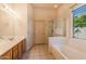 Bathroom with double sinks, soaking tub, and separate shower at 3355 E Los Altos Rd, Gilbert, AZ 85297