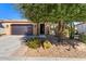 Tan house exterior with a dark garage door and desert landscaping at 856 E Harmony Way, San Tan Valley, AZ 85140