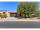 House exterior view showcasing a tan house with a dark garage door and landscaping at 856 E Harmony Way, San Tan Valley, AZ 85140