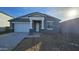 New single-story home with gray exterior, stone accents, and a two-car garage at 37907 N Cowboy Ln, San Tan Valley, AZ 85140