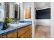 Bathroom with blue tile, wood vanity, and a decorative mirror at 4256 N Desert Oasis Cir, Mesa, AZ 85207