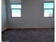 Simple bedroom with neutral-colored carpet and two windows at 24078 W Pecan Rd, Buckeye, AZ 85326