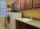 Bright laundry room, washer, dryer, sink, and ample cabinetry at 6216 W Hedgehog Pl, Phoenix, AZ 85083