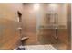 Large walk-in shower with copper tiles and hexagonal floor at 14950 W Mountain View Blvd # 4205, Surprise, AZ 85374