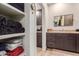 Bathroom with linen closet, granite countertop, and dark wood cabinets at 14950 W Mountain View Blvd # 4205, Surprise, AZ 85374