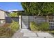Modern metal gate leads to a private courtyard with gravel and plants at 8614 E Berridge Ln, Scottsdale, AZ 85250