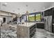 Modern kitchen with a large island, stainless steel appliances, and a view to the living area at 8614 E Berridge Ln, Scottsdale, AZ 85250