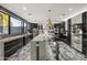 Sleek kitchen boasts dark cabinetry, quartz countertops, and large windows at 8614 E Berridge Ln, Scottsdale, AZ 85250