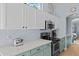 Modern kitchen with white and teal cabinets, quartz countertops and herringbone backsplash at 15912 W Central St, Surprise, AZ 85374