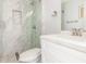 Modern bathroom with white cabinets, marble tile shower, and a toilet at 4302 N 80Th Ln, Phoenix, AZ 85033