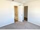 Spacious bedroom with carpet flooring and access to the bathroom at 8572 W Raven Dr, Arizona City, AZ 85123