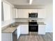 Modern kitchen featuring white cabinets, granite countertops, and stainless steel appliances at 8572 W Raven Dr, Arizona City, AZ 85123