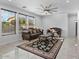 Living room with two sofas, coffee table, and area rug. Features large windows and ceiling fan at 3535 E Melody Ln, Gilbert, AZ 85234