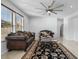 Living room with two sofas, coffee table, and area rug. Features large windows and ceiling fan at 3535 E Melody Ln, Gilbert, AZ 85234