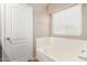 Relaxing bathroom with a bathtub, window, and neutral color scheme at 813 E Lovegrass Dr, San Tan Valley, AZ 85143