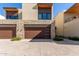Modern home with stone and wood accents, featuring a two-car garage and landscaped grounds at 6311 E Phoenician Blvd # 18, Scottsdale, AZ 85251