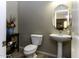 Clean bathroom with pedestal sink, toilet, and oval mirror at 1757 E Wildflower Ln, Casa Grande, AZ 85122