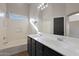 Bathroom with double vanity, bathtub, and dark cabinets at 8841 W Minnezona Ave, Phoenix, AZ 85037