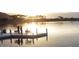 Tranquil lakefront dock with seating area at sunset at 9520 S Krista W Dr, Goodyear, AZ 85338