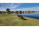 Serene lake view with bench and lush grass at 40140 W Elm Dr, Maricopa, AZ 85138