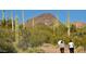 Couple hiking on a desert trail with cacti and mountains in the background at 3131 E Legacy Dr # 1113, Phoenix, AZ 85042