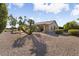 View of home's back exterior, featuring a covered patio and desert landscaping at 3507 N Snead Dr, Goodyear, AZ 85395