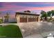 Three-car garage with stone facade and wooden doors at 3507 N Snead Dr, Goodyear, AZ 85395