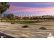 View of a lush green golf course with residential homes in the background at 3507 N Snead Dr, Goodyear, AZ 85395