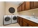 Bright laundry room, washer, dryer, cabinets, and sink at 3507 N Snead Dr, Goodyear, AZ 85395