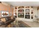 Living room with a built-in entertainment center, fireplace, and leather sofas at 3507 N Snead Dr, Goodyear, AZ 85395