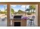 Outdoor kitchen with grill, bar seating, and view at 3507 N Snead Dr, Goodyear, AZ 85395
