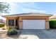 Tan house with a white two-car garage and well-manicured lawn at 40710 N Boone Ln, Anthem, AZ 85086