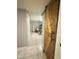 Hallway with a rustic barn door leading to the living room at 6943 W Virginia Ave, Phoenix, AZ 85035