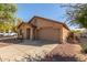 Tan house with a two-car garage and landscaping at 16019 W Moreland St, Goodyear, AZ 85338