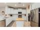 Modern kitchen with white cabinets, island and stainless steel appliances at 26984 W Yukon Dr, Buckeye, AZ 85396