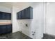 Laundry room with dark blue cabinets and tile flooring at 19537 N 69Th Ave, Glendale, AZ 85308