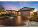 House exterior at dusk featuring a two-car garage and landscaping at 31153 N 117Th Dr, Peoria, AZ 85383