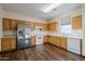 Kitchen with wood cabinets, stainless steel appliances, and hardwood floors at 5138 W Fulton St, Phoenix, AZ 85043