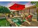 Patio furniture under a red umbrella in a backyard setting at 18903 N 97Th Ln, Peoria, AZ 85382