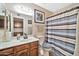 Neat bathroom featuring a shower/tub combo and wood vanity at 18903 N 97Th Ln, Peoria, AZ 85382