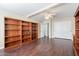 Well-lit bedroom featuring dark wood flooring and extensive built-in shelving at 1663 S Boulder St, Gilbert, AZ 85295