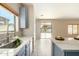 Kitchen features blue cabinets, marble countertops, and backyard access at 25575 W Lynne Ln, Buckeye, AZ 85326