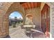 Stone patio with arched entryways, outdoor dining seating, and scenic views at 27440 N Alma School Pkwy # 116, Scottsdale, AZ 85262